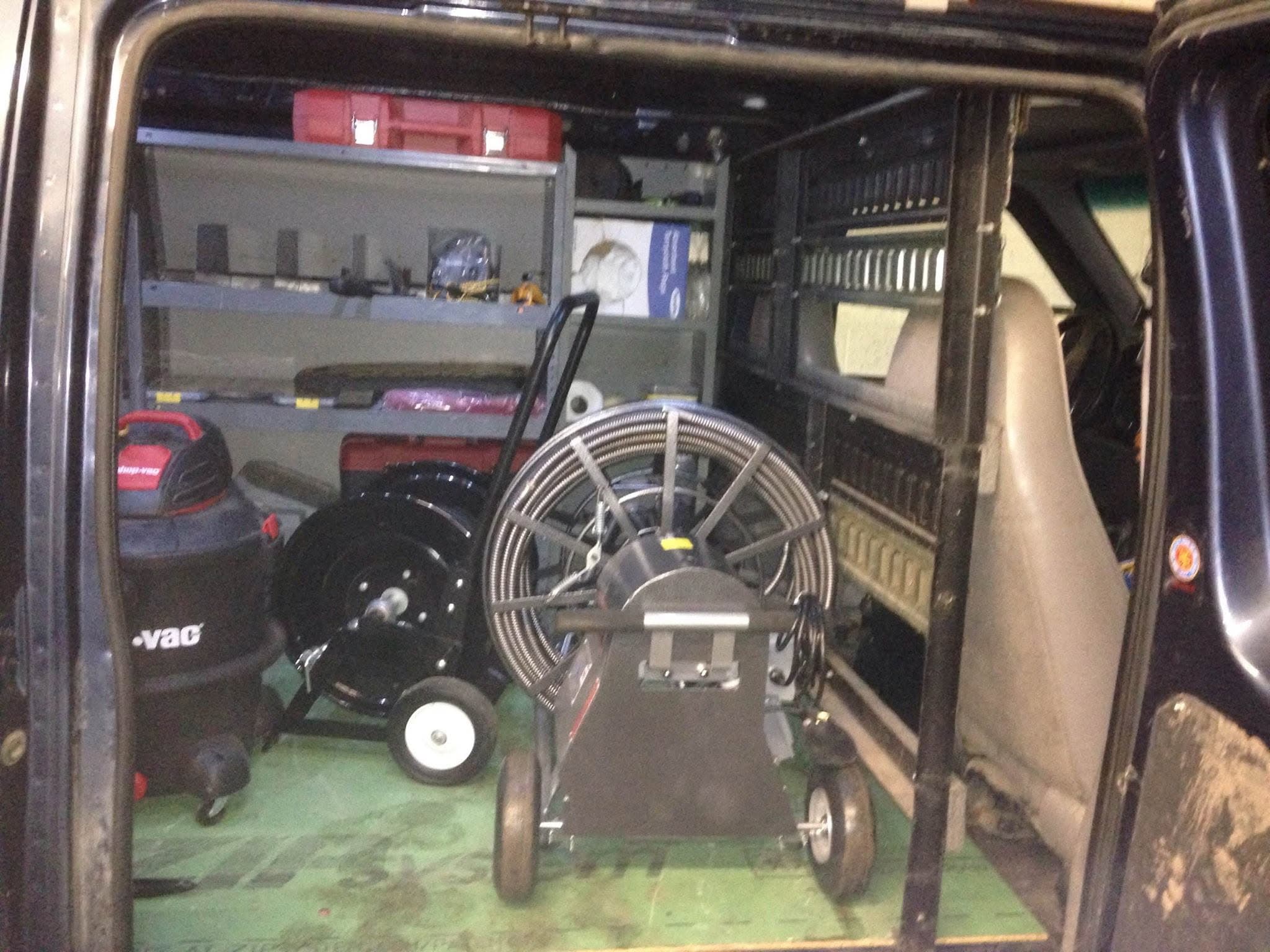 Organized service van stocked with drain cleaning equipment